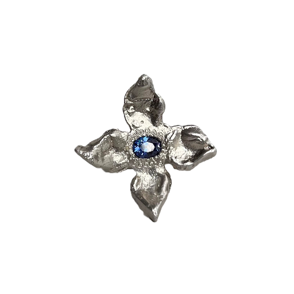 Recycled sterling silver & synthetic gemstone
A delightful ring in the shape of a flower. The ring sits on a d-shaped band and hosts a bright deep blue synthetic stone in the centre. Each flower is carved from wax and cast individually ensuring your piece is a unique edition with one-of-a-kind organic textures.